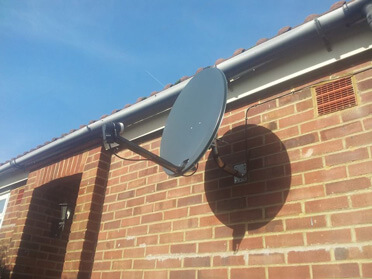 Picture of a satellite dish on brickwork