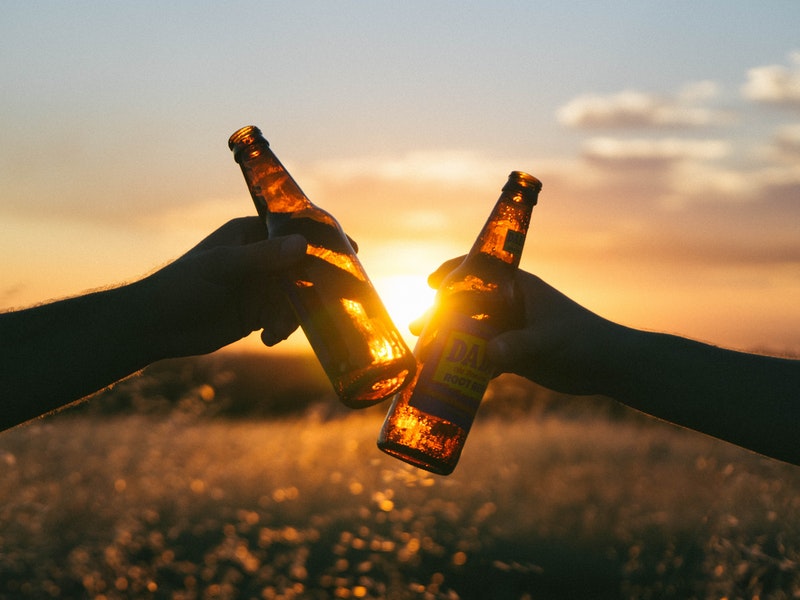 2 people hitting Beer bottles together