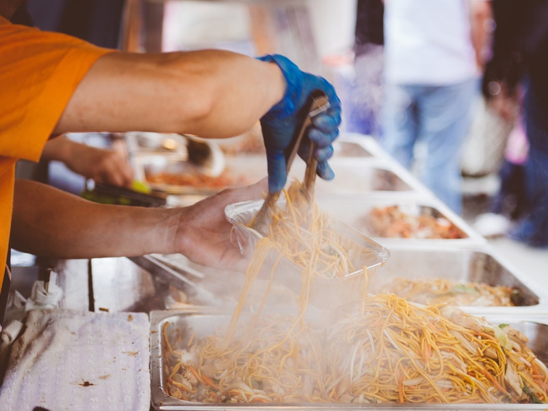 man's arms serving french fries at festival