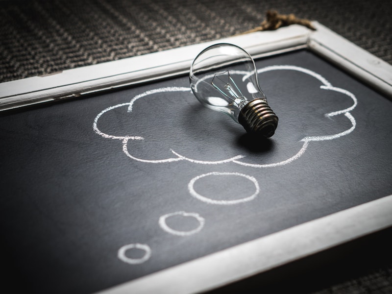 chalk board with drawn thought-bubble and a lightbulb