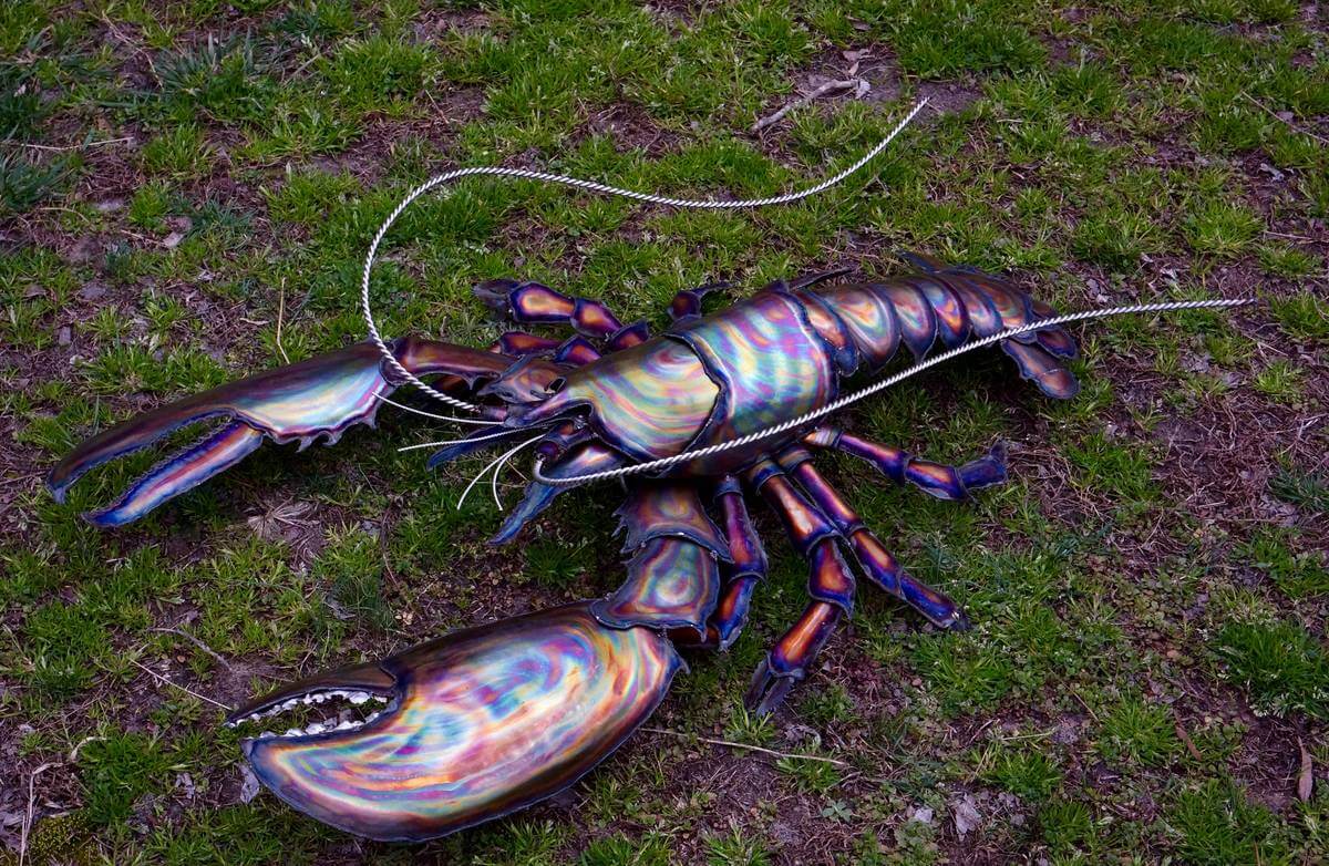 Metal striped lobster sculpture going for a walk