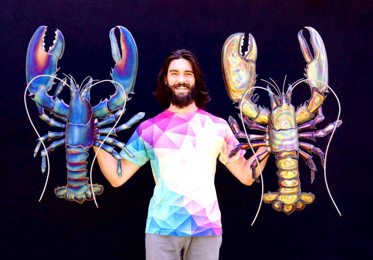 Artist Aiden Dale with his metal blue lobster and striped lobster sculptures