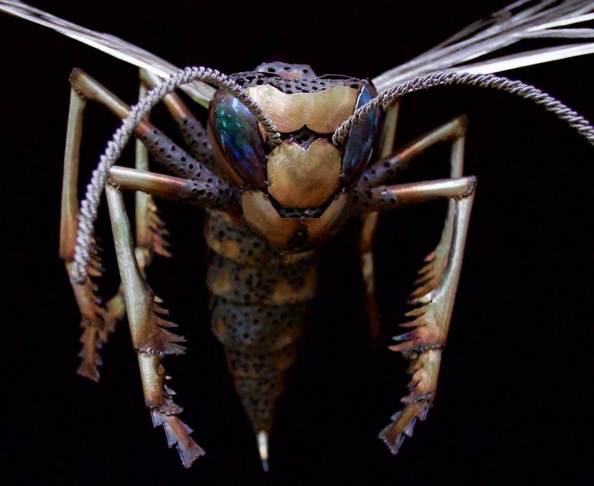 Close up of the face and antenna of a metal wasp sculpture