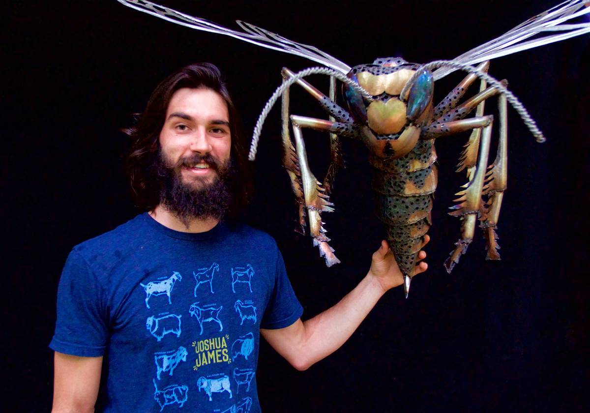 Artist Aiden Dale with metal wasp sculpture