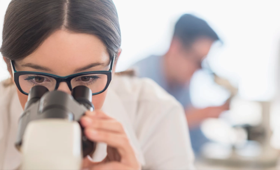 Cientista observadora microscopio