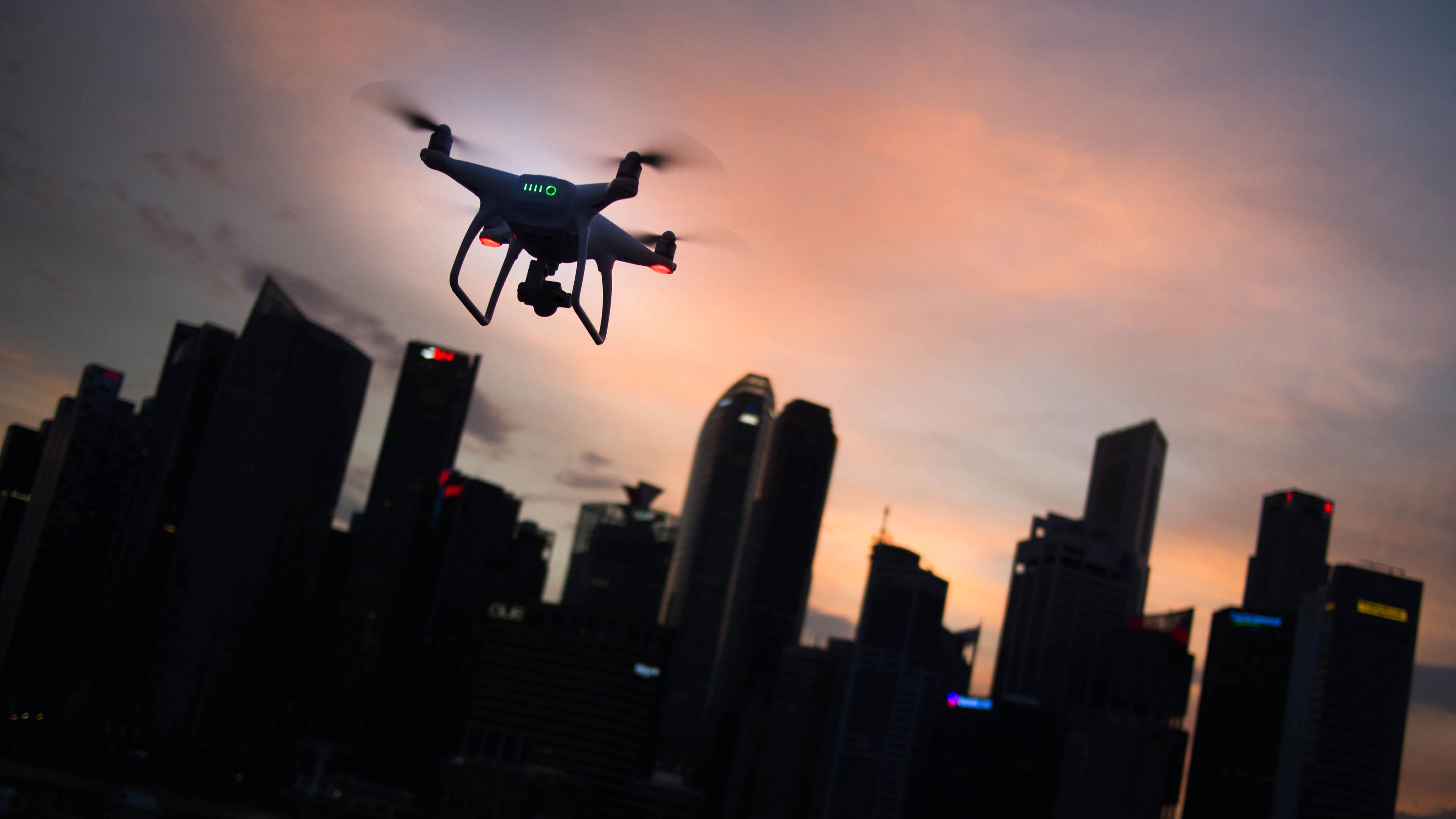 Drone sobrevoando cidade ao entardecer.