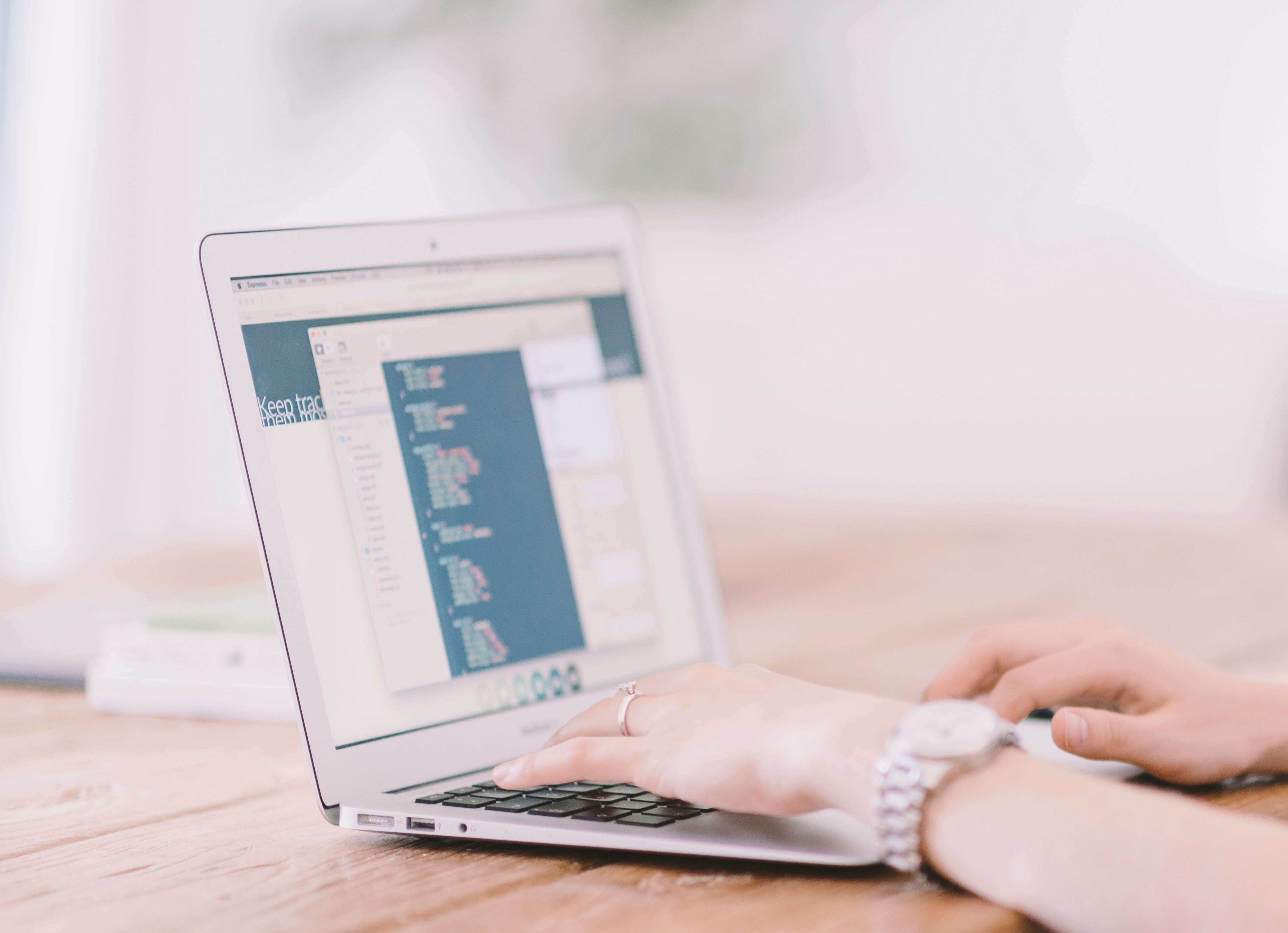 A woman types in code on a laptop