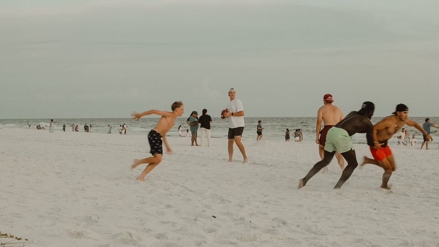 Valor reps playing football on the beach in Destin, Florida